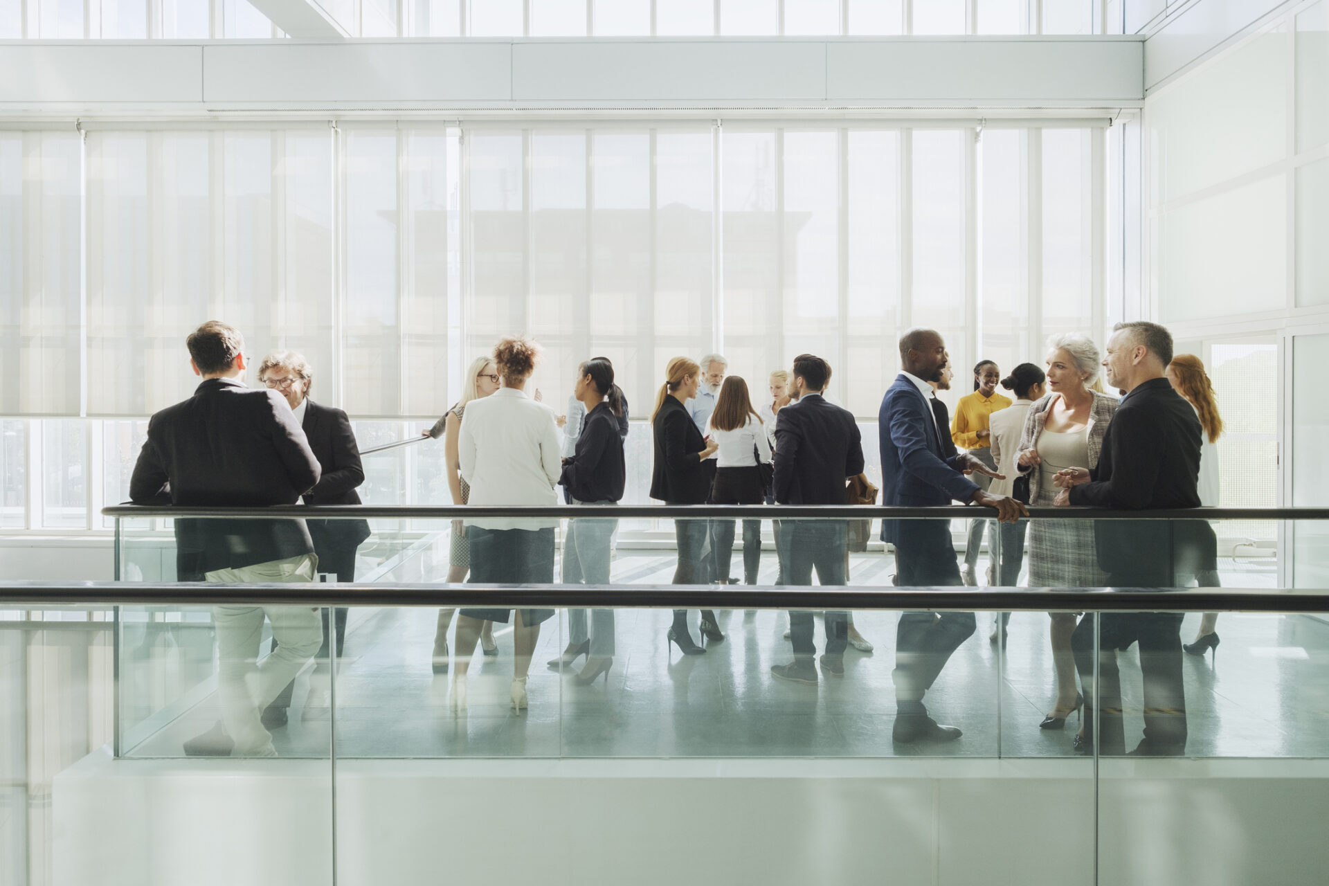 A group of people standing around in front of glass.